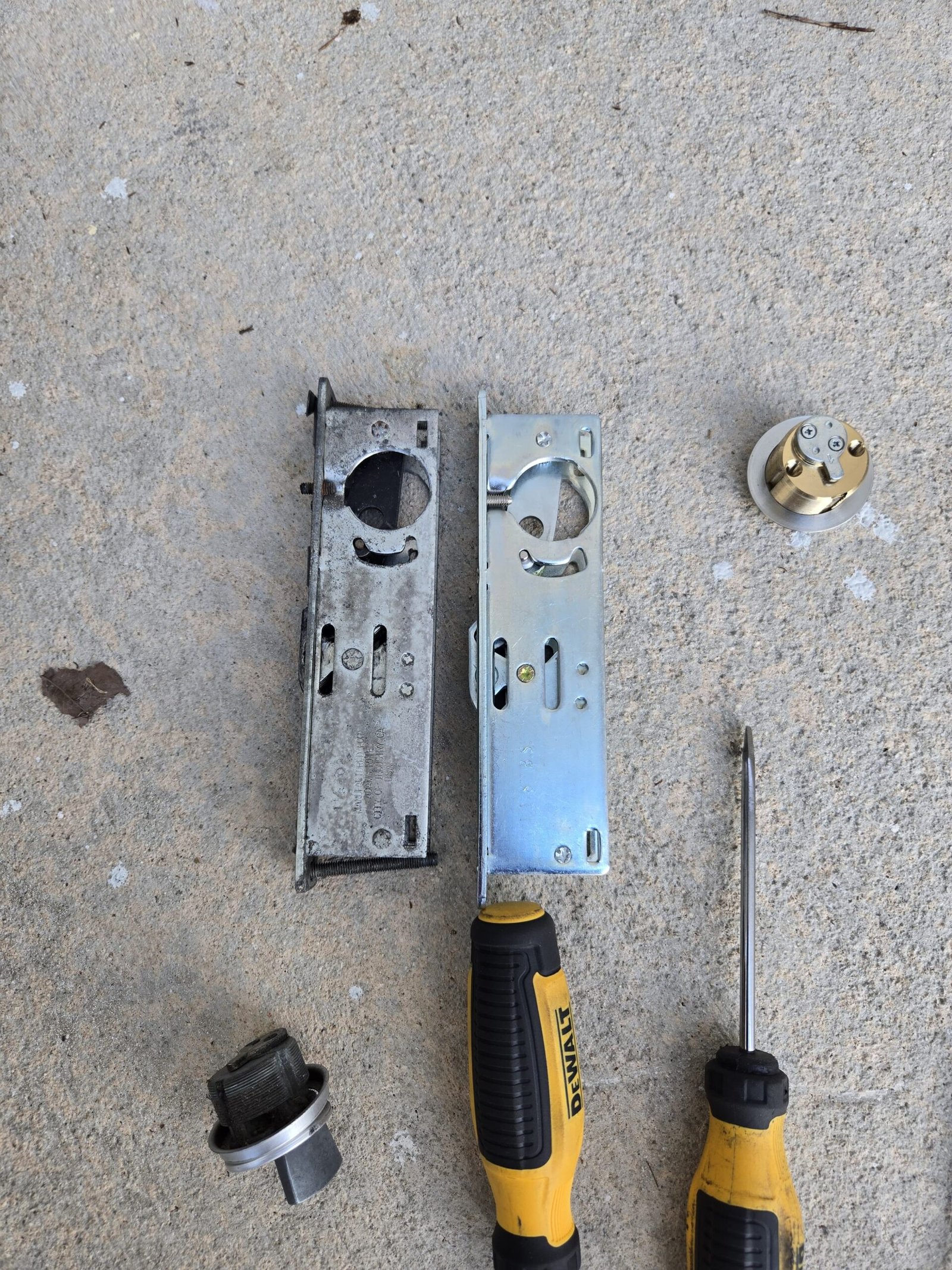 Old and replacement storefront lock mechanisms during commercial door repair