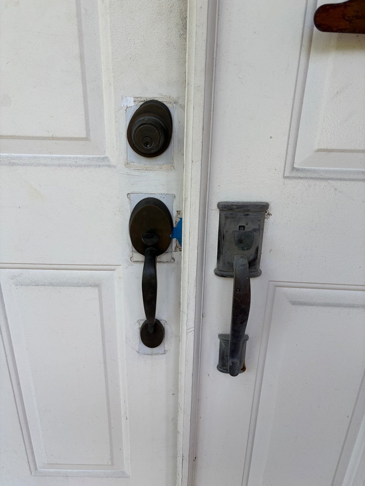 Worn residential double-door handles and deadbolt before lock replacement